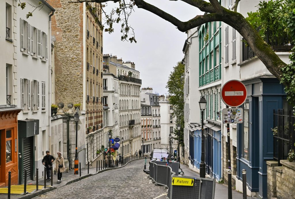 Explore the charming streets of Montmartre, Paris with its classic European architecture and vibrant city life.